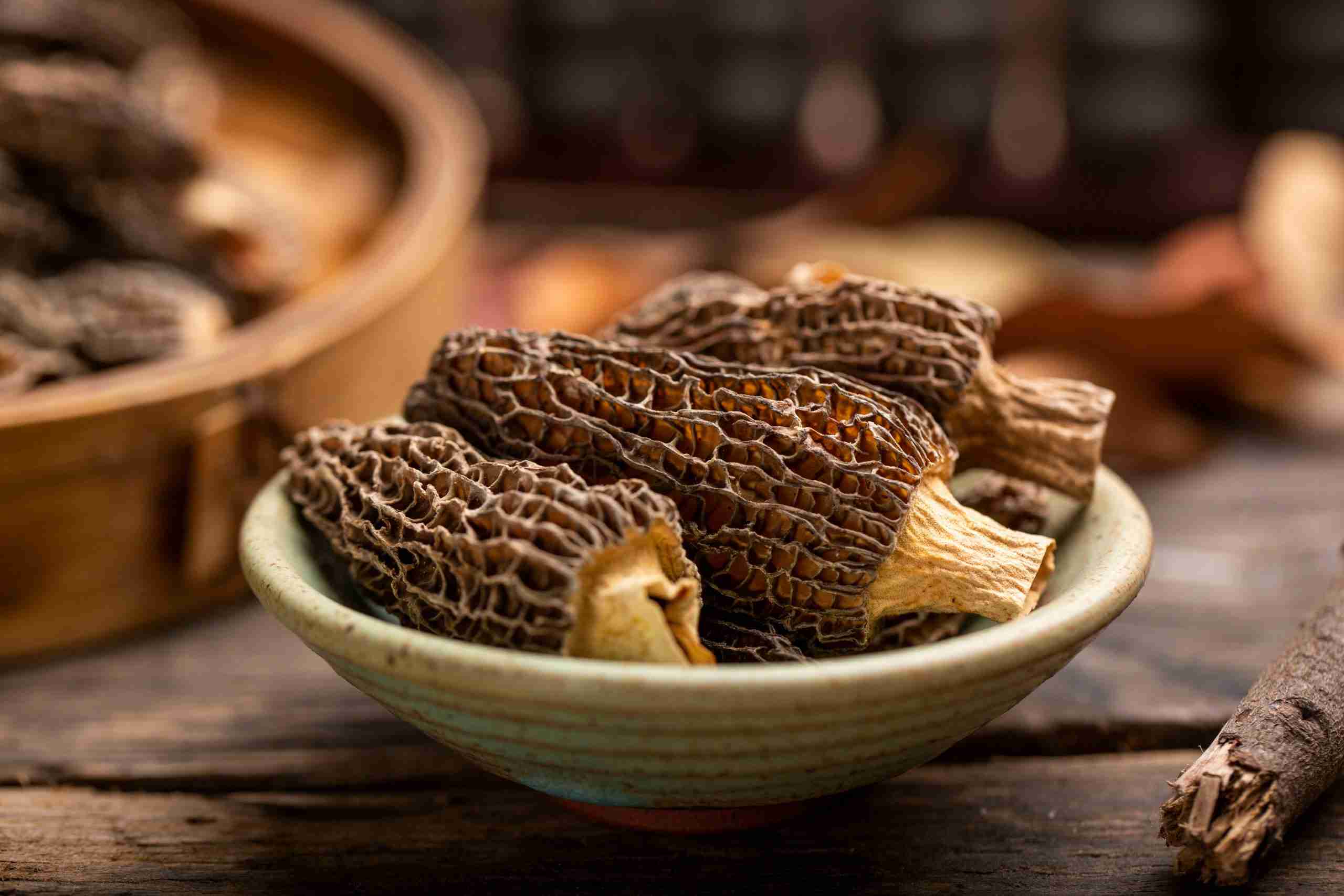 Fresh morel mushrooms with distinctive honeycomb caps being prepared for cooking on a cutting board